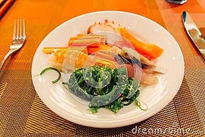 Seafood Japanesse dinner Salmon, Tuna, Crab Stick, Sushi, Seaweed on a plate at the hotel. Stock Photo