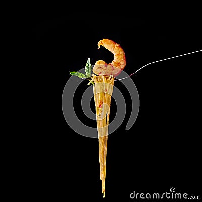 Seafood pasta with shrimp and mint leaf at fork. spanish and italian cuisine concept at black backdrop. Copy space Stock Photo