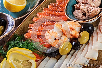 Seafood platter. Fresh cod liver, salmon, shrimp, slices fish fillet, decorated with herb, Stock Photo