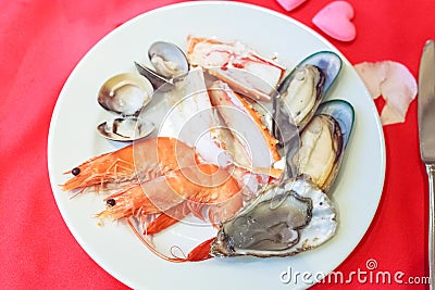 Seafood Platter Lover: fresh sweet shrimps, raw snow crab meat, mussels, oyster, clams and enamel venus shells served in white Stock Photo