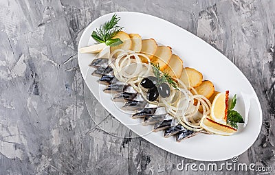 Seafood platter with smoked mackerel slice, fried potatoes, slices fish fillet, decorated with onion over rustic background Stock Photo