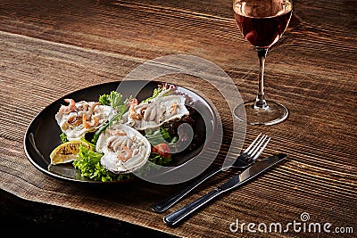 Seafood. Restaurant cuisine, healthy delicatessen food. Oysters, shrimps, octopus in white cream sauce in the shell of Stock Photo