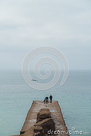 Seaford, East Sussex | UK - 2021.04.04: Men fishing early morning at the Seven Sisters West beach side Editorial Stock Photo