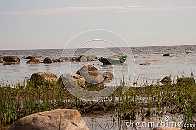 Seafront with seaweed and tethered boat Stock Photo