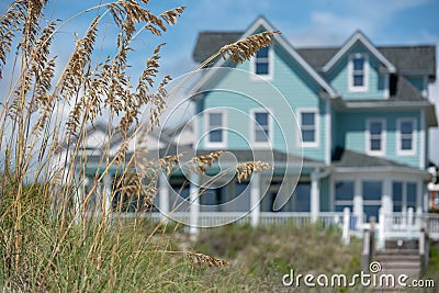 Teal coastal beach house with seagrass in the foreground Stock Photo