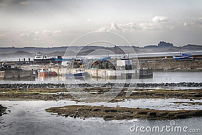 Seahouses Harbour in Northumberland with Bamburgh Castle Stock Photo