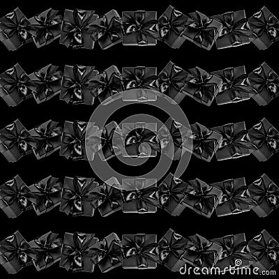 Seamless pattern made of rows of black wrapped gift boxes decorated with bows on black Square format Stock Photo