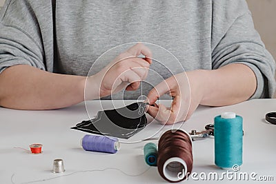 Seamstress does running stitch a pattern pieces of clothing Stock Photo