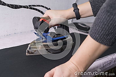 Seamstress master, in the sewing salon, using the iron, the master irones the clothes Stock Photo