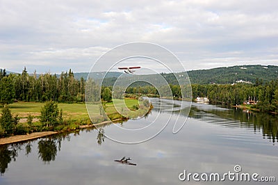 A seaplane or water plane takes off on the river in Alaska. Stock Photo