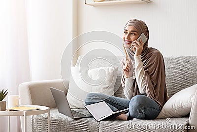 Muslim Girl Talking On Cellphone At Home, Making Work Interview Appointment Stock Photo