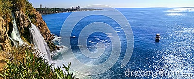 Seascape of Duden Waterfall with a boat in the sea near it Antalya, Turkey. Colorful panorama with Turkish landmarks on a sunny Stock Photo