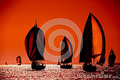 Sailing boats silhouette in the high sea on orange sunset Stock Photo