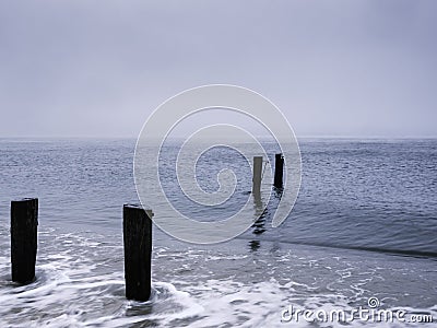 Seascape with four pilings of ruined piers Stock Photo