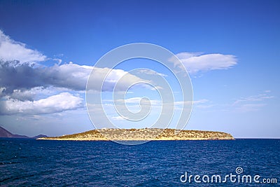 Seascape in Greece. Small greek island, Mediterranean sea, blue sky with clouds. Seascape with islet. Stock Photo