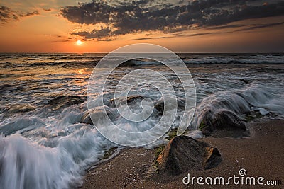 Seascape with long exposed waves and round rocks Stock Photo