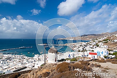Seascape from Mykonos, Greece. Village windmill on mountain landscape by blue sea. White houses on cloudy sky with nice Stock Photo