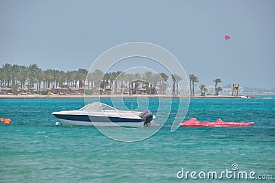 Seascape with ripple surface of blue sea water with white speedboat on anchor floating on calm waves Stock Photo