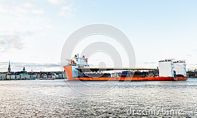 Seascape side view of a large orange semi-submersible heavy-lift ship with large load entering harbor in Stockholm Sweden. Stock Photo