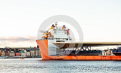 Seascape side view of a large orange semi-submersible heavy-lift ship with large load entering harbor in Stockholm Sweden. Stock Photo