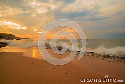 Seascape. Sunset time at the beach. Beach background with footprints in the sand. Tegal Wangi beach, Bali, Indonesia Stock Photo