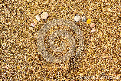 Seashell footprints on the beach. Footprints in the sand. Foot marks on the sand beach with the seashell. Rest by the Stock Photo