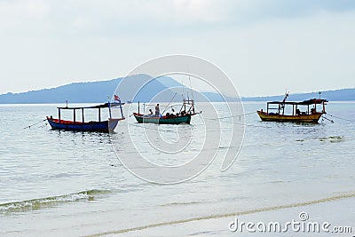 Seaside landscape with cambodian wooden boats and distant island. Idyllic seashore view with traditional khmer boats. Stock Photo