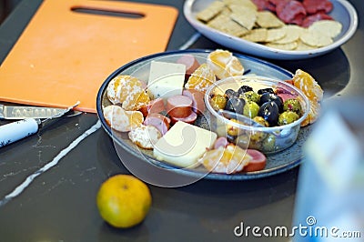 Seasonal appetizer platter with olives, cheese, meat and oranges Stock Photo