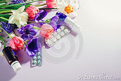 Seasonal spring allergy. Antihistamine pills and nasal spray flat lay with purple pink flowers. Healthcare for allergic Stock Photo