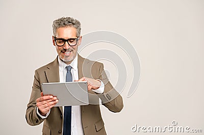 High-skilled senior businessman in formal suit using tablet Stock Photo
