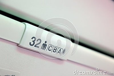 Seat number on luggage shells inside the passenger airplane. Sign of seat for the passenger of airplane with number and letter of Stock Photo