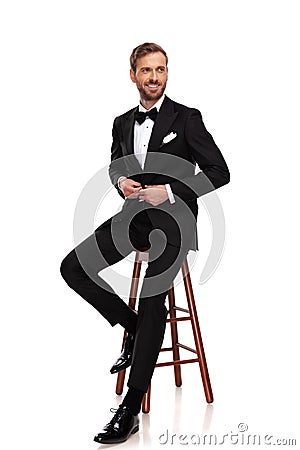 Seated businessman buttons suit and looks to side Stock Photo