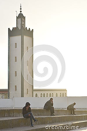 Seated figures near the mosque in Moulay Bousselham, Morocco Editorial Stock Photo