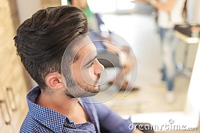 Seated young casual man with nice hairstyle Stock Photo