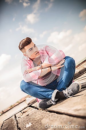 Seated young man bitting his lip Stock Photo