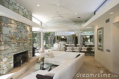 Seating Area And Stone Fireplace With Dining Area In Background Stock Photo