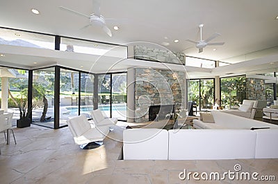 Seating Area And Stone Fireplace In Spacious Living Room With Pool View Stock Photo