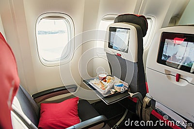 Seats on board of airplane. Cabin of economy class with screens Stock Photo