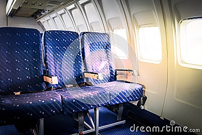 Seats in commercial aircraft cabin with sun light shining throug Stock Photo