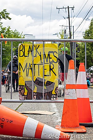 Seattle, WA - 11 June 2020. Black Lives Matter sign held at protest on streets and buildings Editorial Stock Photo