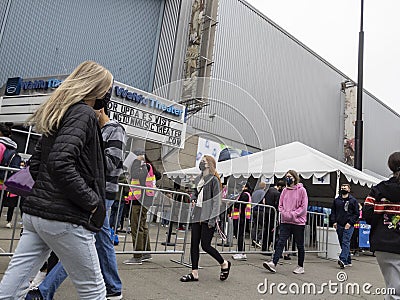 Seattle, WA USA - circa May 2021: View of mask covered people leaving and entering a covid 19 vaccination center at Lumen Field in Editorial Stock Photo