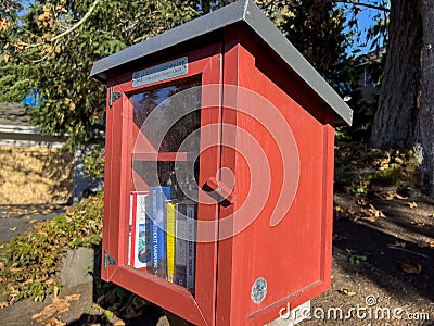 Seattle, WA USA - circa November 2022: Close up view of a red Little Free Library in a residential neighborhood Editorial Stock Photo