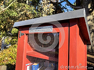 Seattle, WA USA - circa November 2022: Close up view of a red Little Free Library in a residential neighborhood Editorial Stock Photo