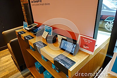 A display of Amazon electronic devices such as, kindle, echo dot, tablet, and echo show at the original U District Amazon Editorial Stock Photo