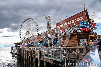 Seattle Washington View from waterfront pier with restaurant and Ferris wheel in view Editorial Stock Photo