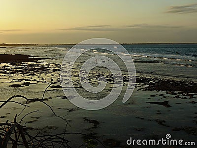 The seawater wave border to exposed rocky seabed in lowest low tide on sunset Stock Photo