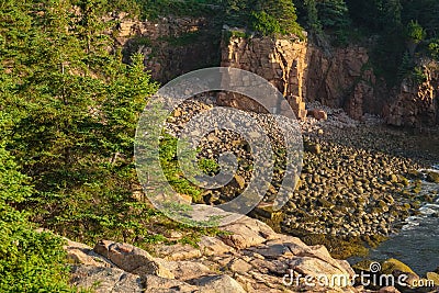 Secluded cove filled with pink granite cliffs and rocky boulders Stock Photo