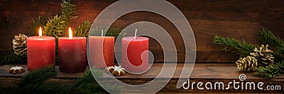 Second Sunday in Advent, four red candles, two of them are burning, fir branches and Christmas decoration on dark rustic wood, Stock Photo