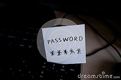 Secret password written on paper note on keyboard with wooden desk on background. Login access, encryption and cyber security con Stock Photo