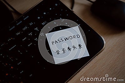 Secret password written on paper note on keyboard with wooden desk on background. Login access, encryption and cyber security con Stock Photo